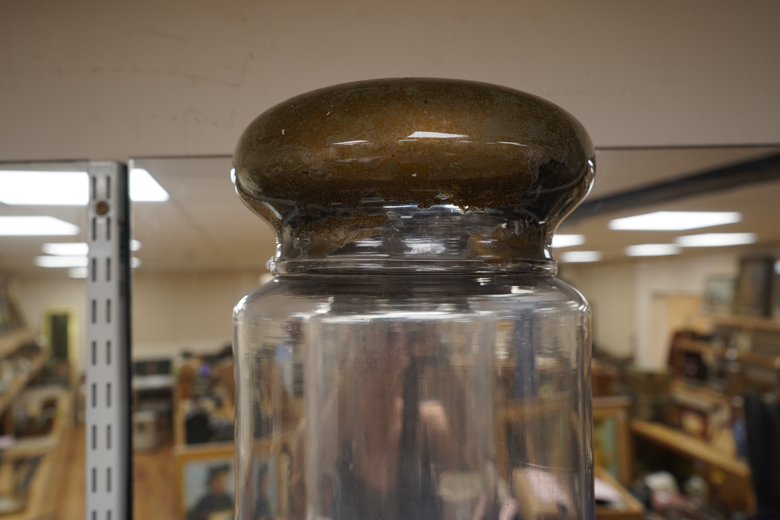 An 18th century cylindrical glass drug jar with remnants of gilding to the lid, 42cm high